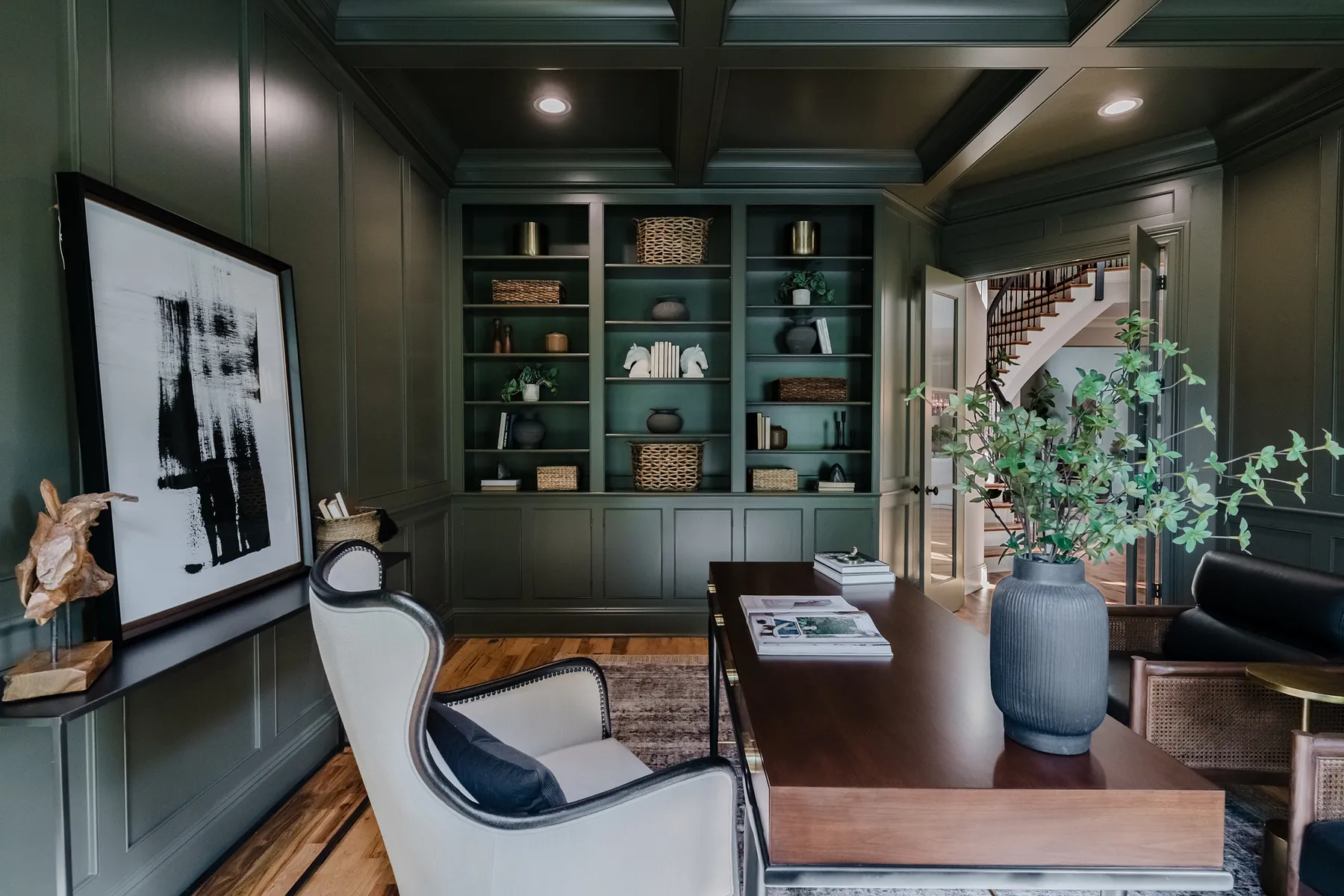 Study panelled in deep green with built-in shelving and a coffered ceiling